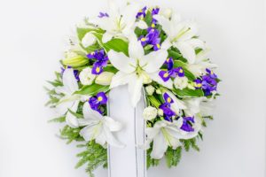 Matusepärg kuuseoksal valgete liiliate ja siniste lilledega